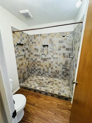 a bathroom with a shower toilet and sink