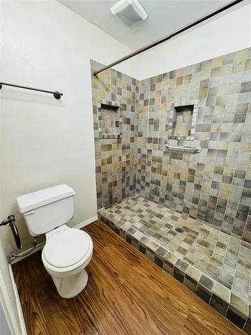 a bathroom with a toilet and a shower