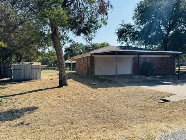 a backyard of a house with wooden fence and trees