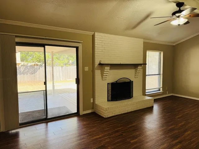 a view of a livingroom with a fireplace wooden floor and brick walls