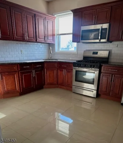 a kitchen with granite countertop a stove microwave and sink