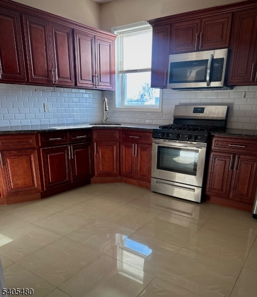 245 22nd Street Irvington, NJ 07111 - Photo 1 of 17 a kitchen with granite countertop a stove microwave and sink