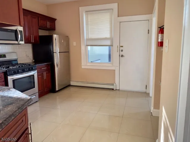a kitchen with stainless steel appliances granite countertop a refrigerator and a stove top oven