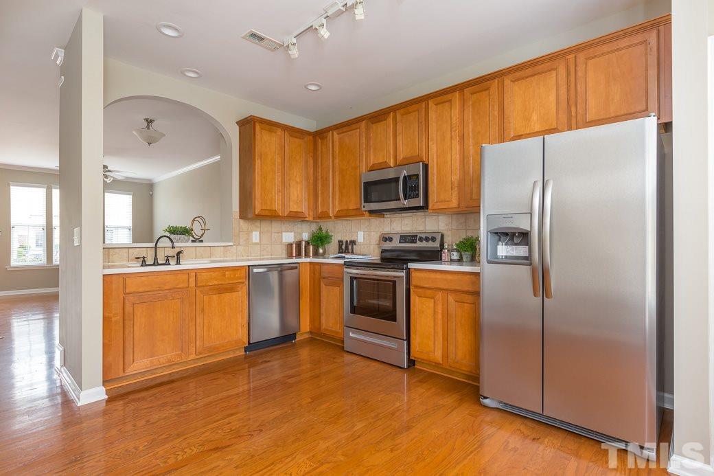 7739 Winners Edge Street Raleigh, NC 27617 - Photo 2 of 12 a kitchen with stainless steel appliances granite countertop a refrigerator a stove top oven a sink and dishwasher