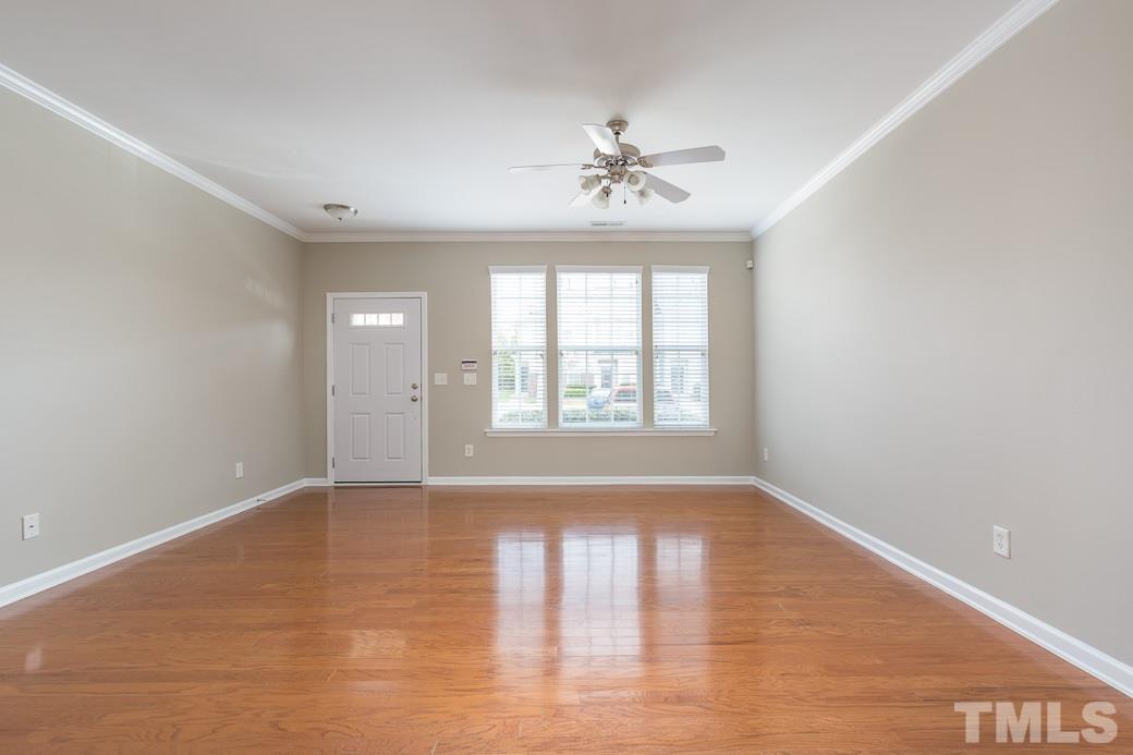7739 Winners Edge Street Raleigh, NC 27617 - Photo 4 of 12 a view of an empty room with wooden floor and a window