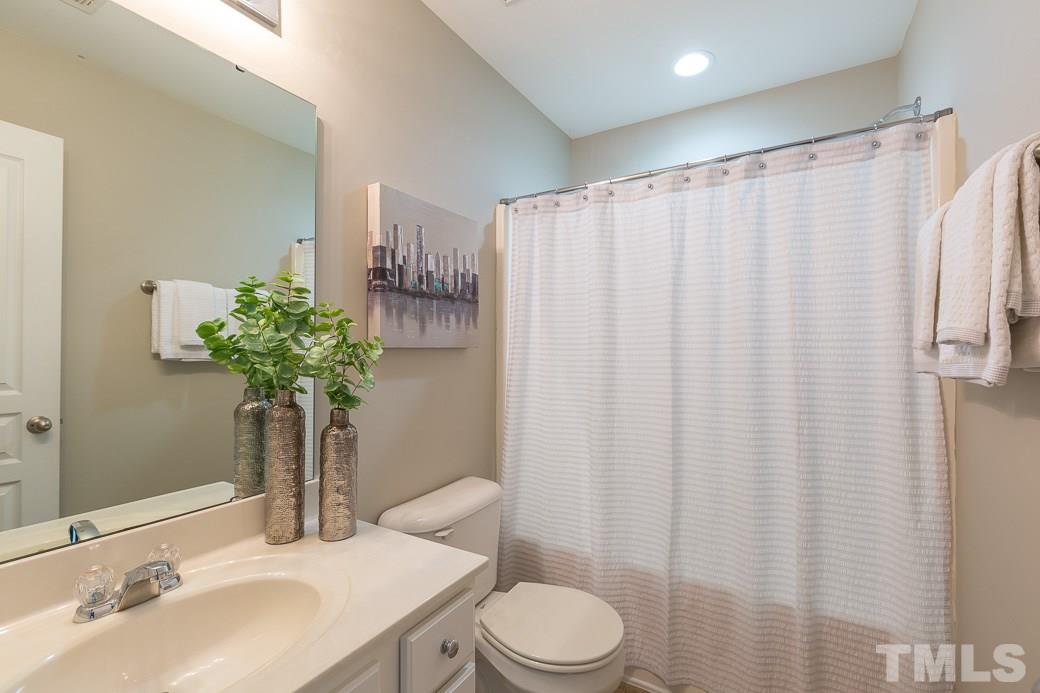 7739 Winners Edge Street Raleigh, NC 27617 - Photo 7 of 12 a bathroom with a toilet a sink and a mirror