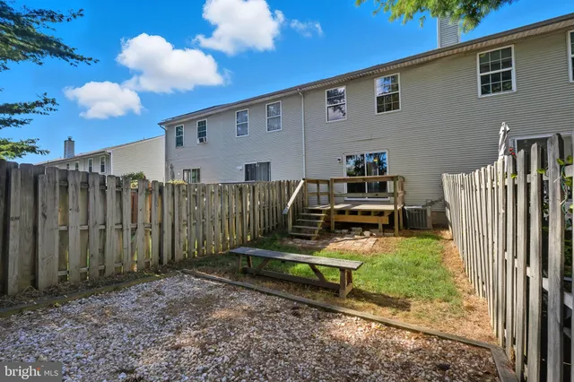 a backyard of a house with a small barn and wooden fence