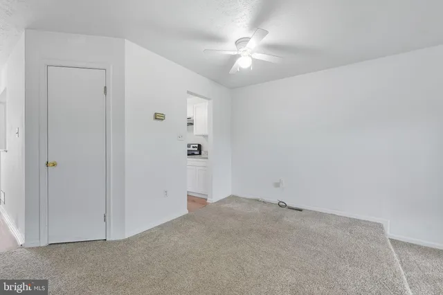an empty room with chandelier fan