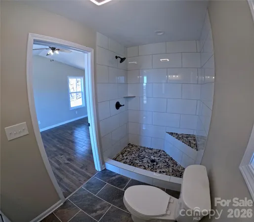 a bathroom with a sink a toilet a mirror and shower