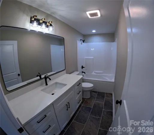 a bathroom with a double vanity sink mirror and toilet