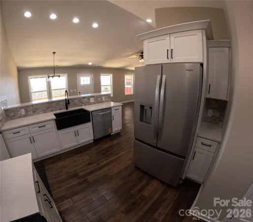 a kitchen with granite countertop a refrigerator and a sink