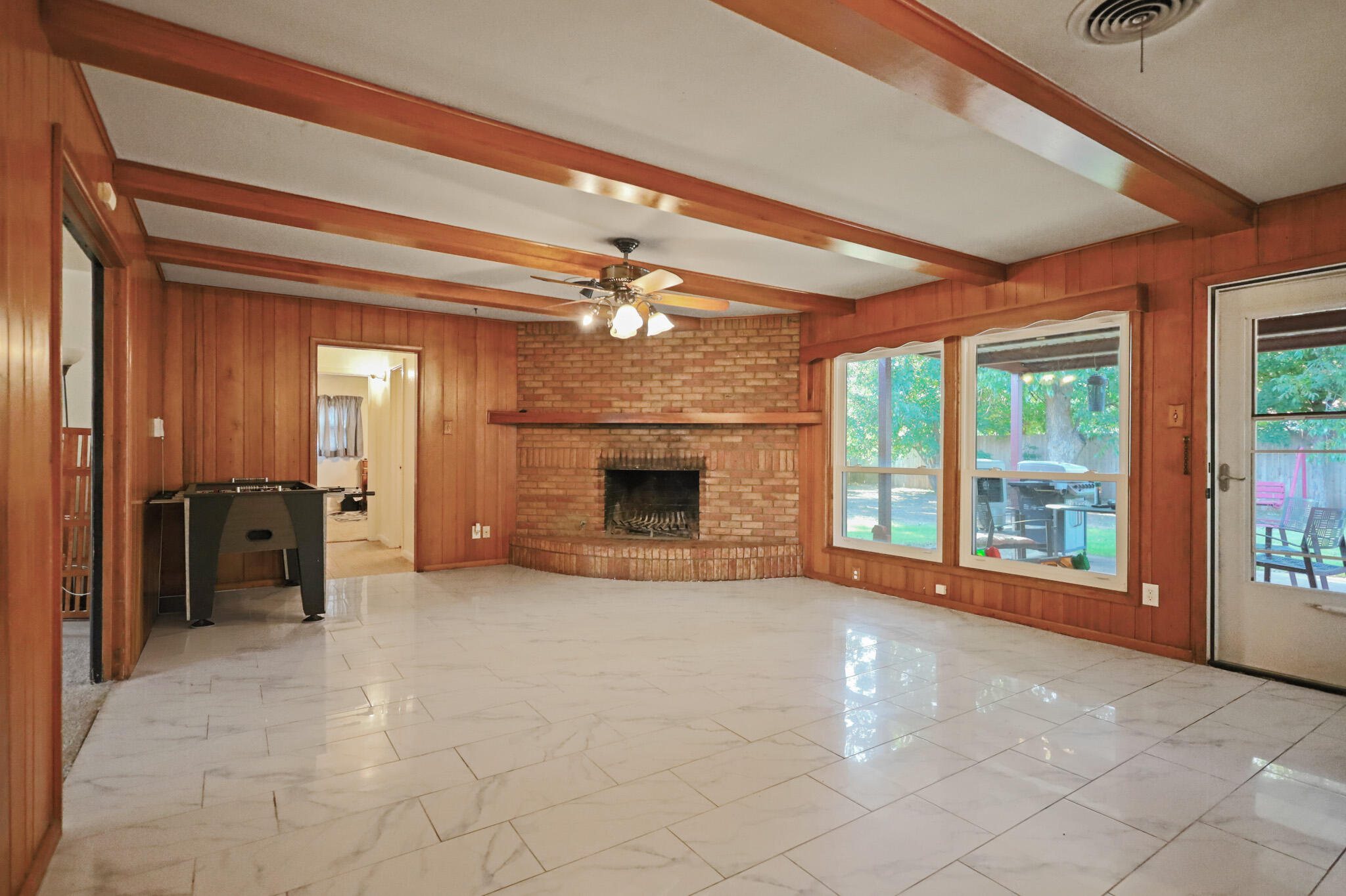 5209 17th Street Lubbock, TX 79416 - Photo 13 of 40 a view of an empty room with a fireplace and a chandelier