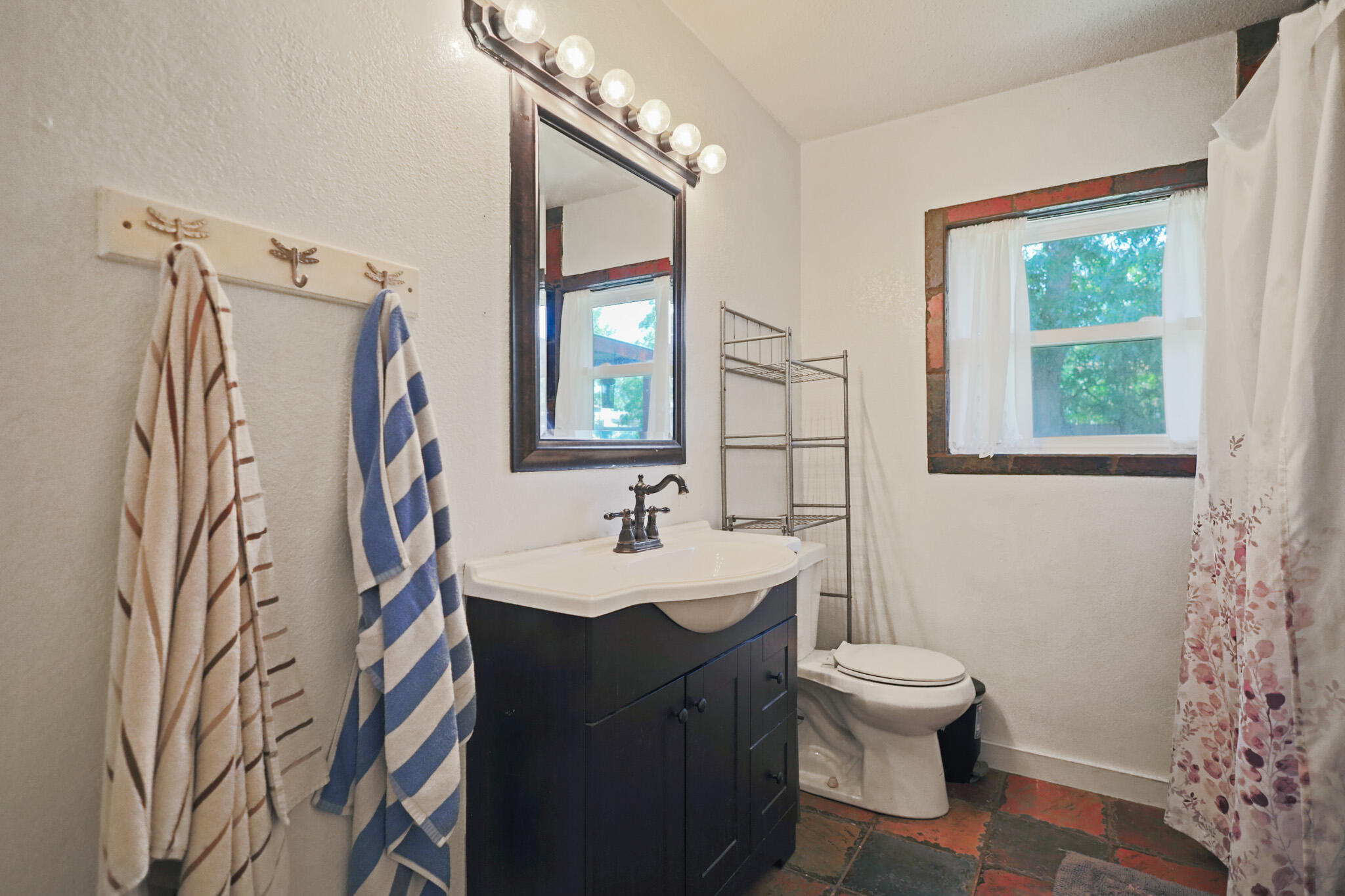 5209 17th Street Lubbock, TX 79416 - Photo 25 of 40 a bathroom with a sink toilet and mirror