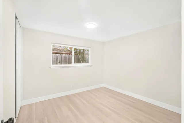 a view of a hallway with wooden floor and closet area
