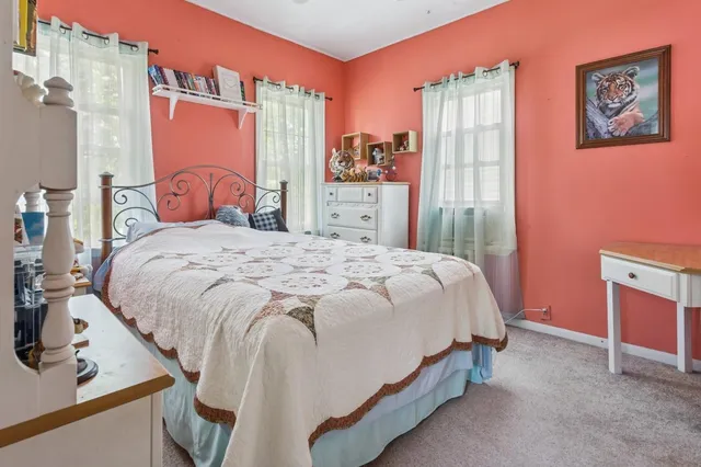 a bed sitting in a bedroom next to a window