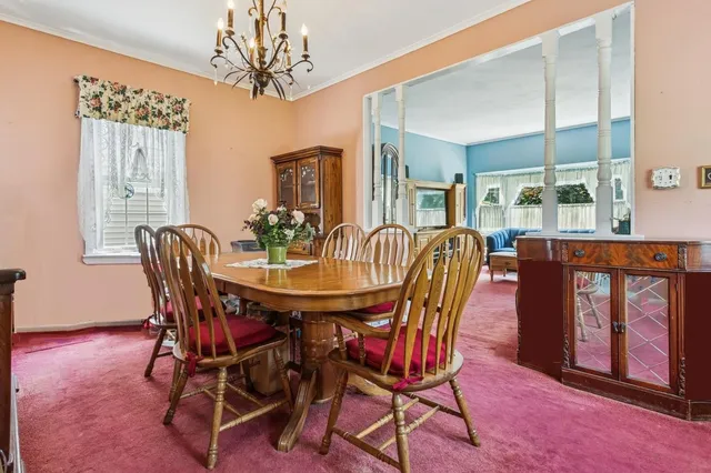 a dining room with furniture a chandelier and window