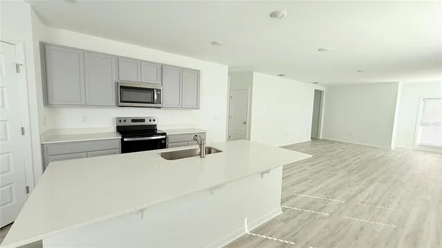 a kitchen with stainless steel appliances a microwave a sink and cabinets
