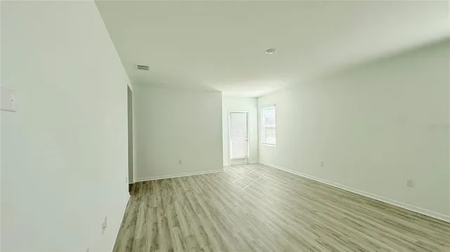 a view of an empty room and wooden floor