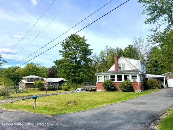 a front view of a house with a yard and trees
