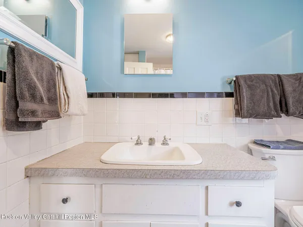 a bathroom with a granite countertop sink a mirror and vanity