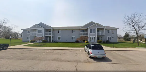 a car parked in front of a house with a yard