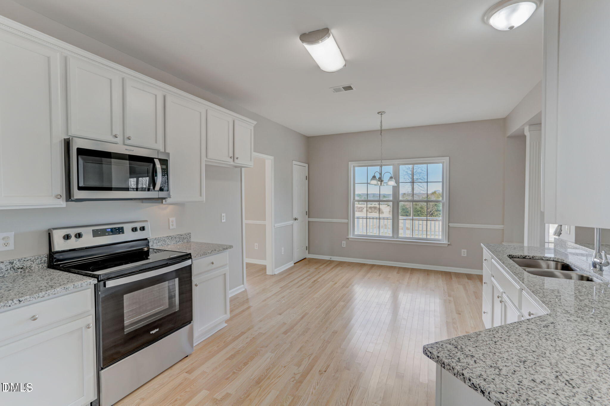 480 Seastone Street Raleigh, NC 27603 - Photo 6 of 26 a kitchen with granite countertop a stove a sink and a microwave