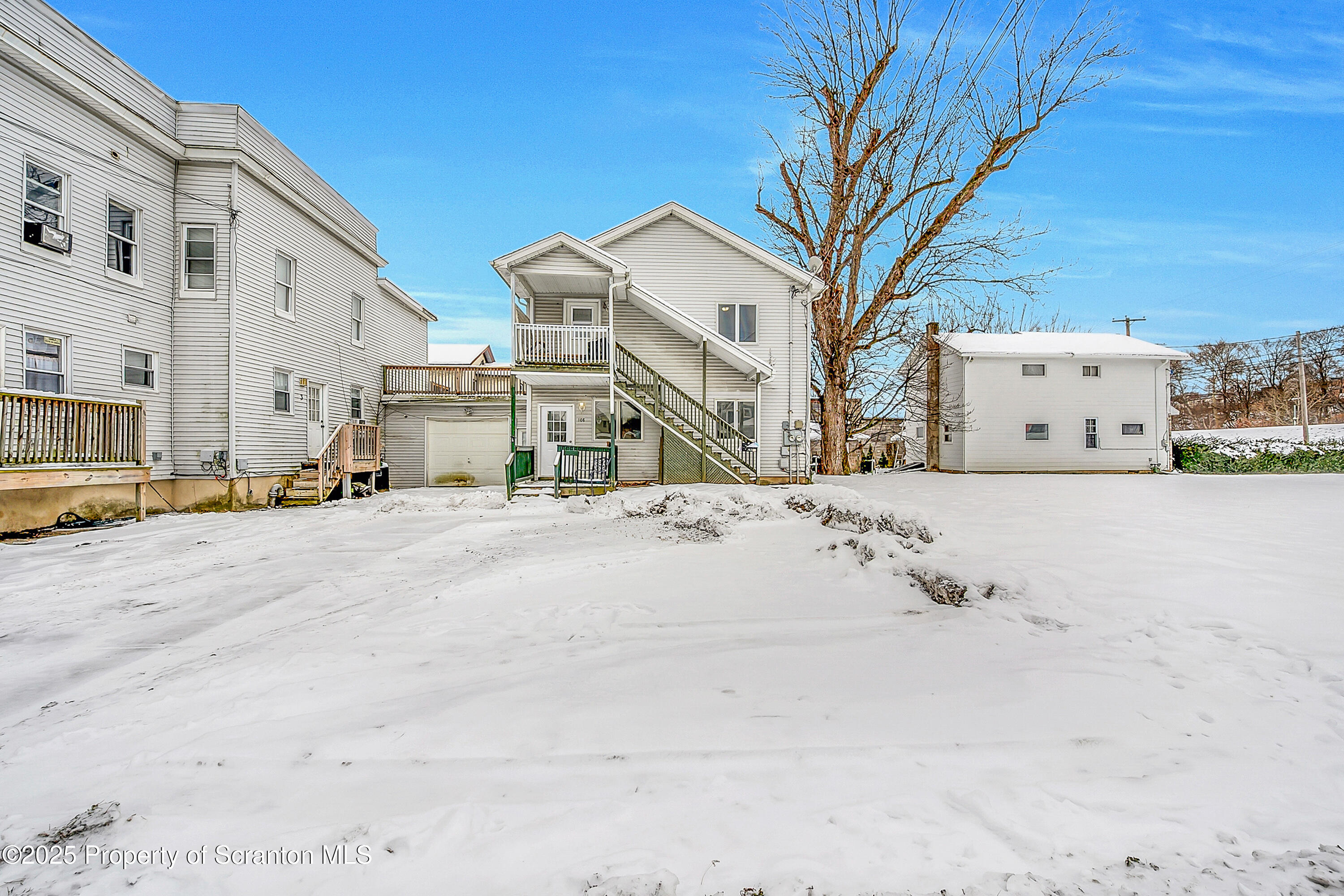 a view of a white house with a snow on the road