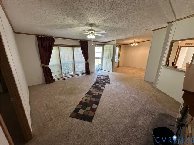 a view of a hallway with a chandelier fan and livingroom view