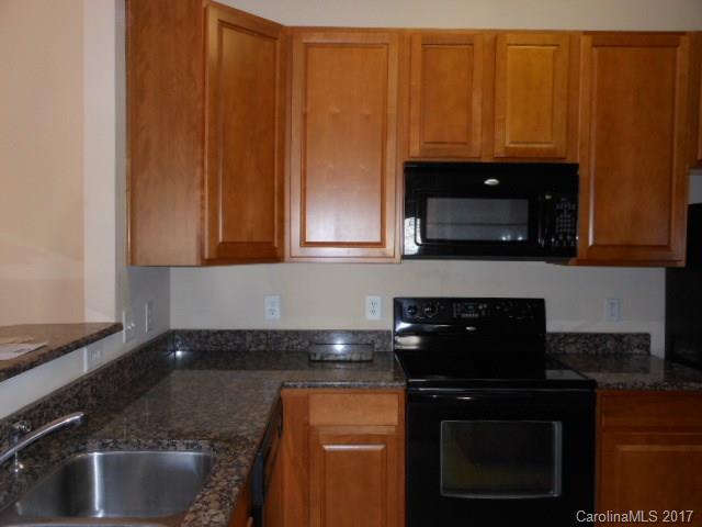 16644 Amberside Road East, Unit E Cornelius, NC 28031 - Photo 5 of 16 a kitchen with granite countertop stainless steel appliances a stove a microwave and sink
