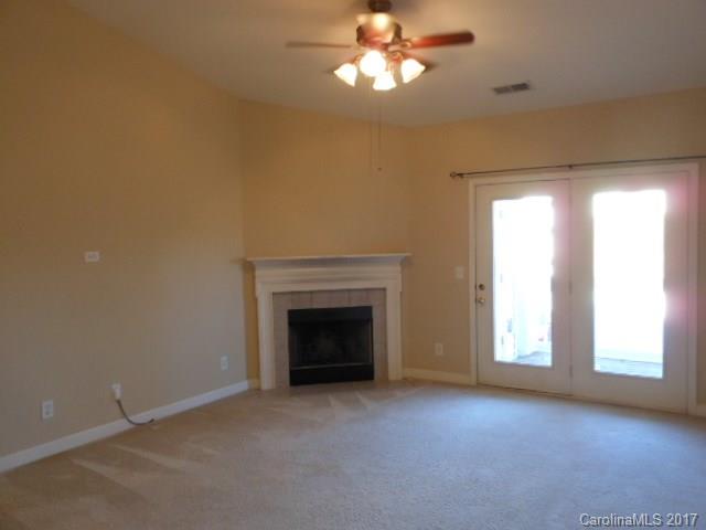 16644 Amberside Road East, Unit E Cornelius, NC 28031 - Photo 7 of 16 an empty room with a fireplace and windows
