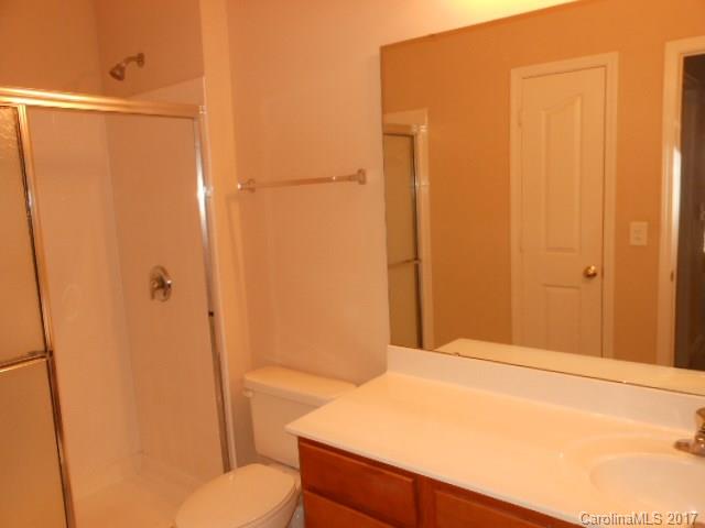 16644 Amberside Road East, Unit E Cornelius, NC 28031 - Photo 10 of 16 a bathroom with a granite countertop sink toilet and shower