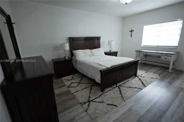a bedroom with a bed and wooden floor
