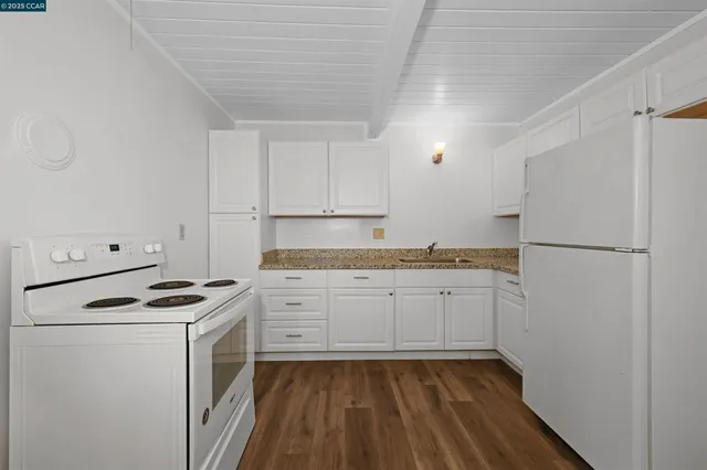 a kitchen with granite countertop cabinets stainless steel appliances and a sink