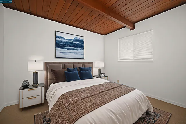 a bedroom with bed and a painting on the wall