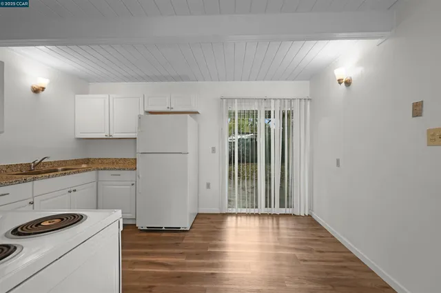 a kitchen with a refrigerator and white cabinets