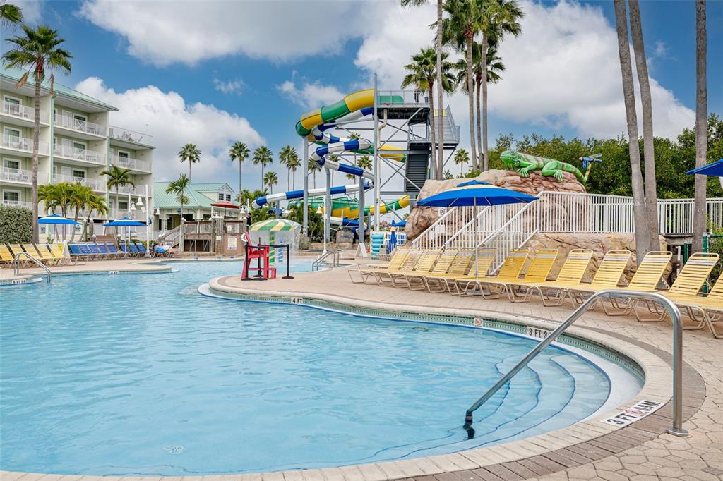 399 2nd Street, Unit 219 Indian Rocks Beach, FL 33785 - Photo 38 of 46 a view of a swimming pool with a lawn chairs and potted plants