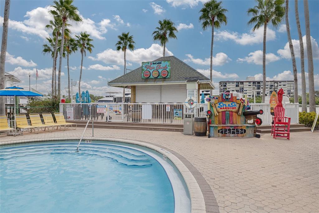 399 2nd Street, Unit 219 Indian Rocks Beach, FL 33785 - Photo 39 of 46 a view of a swimming pool with a bench and chairs