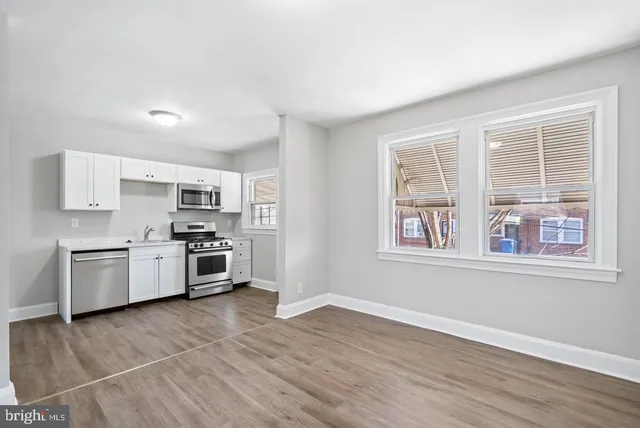a kitchen with stainless steel appliances a white cabinets and a window