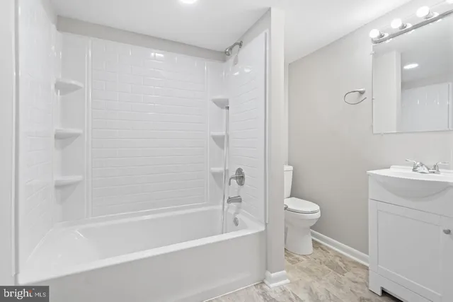a bathroom with a bathtub shower sink vanity and toilet
