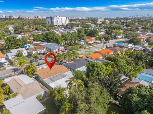an aerial view of residential houses with outdoor space and parking