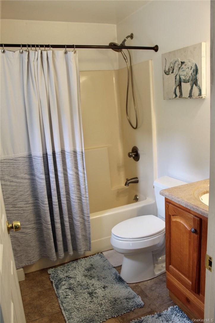 5834 Albany Post Road Cortlandt Manor, NY 10567 - Photo 8 of 14 Full bathroom with shower / tub combo, tile patterned flooring, vanity, and toilet