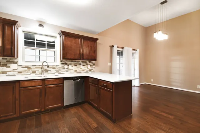 a kitchen with a sink cabinets and wooden floor