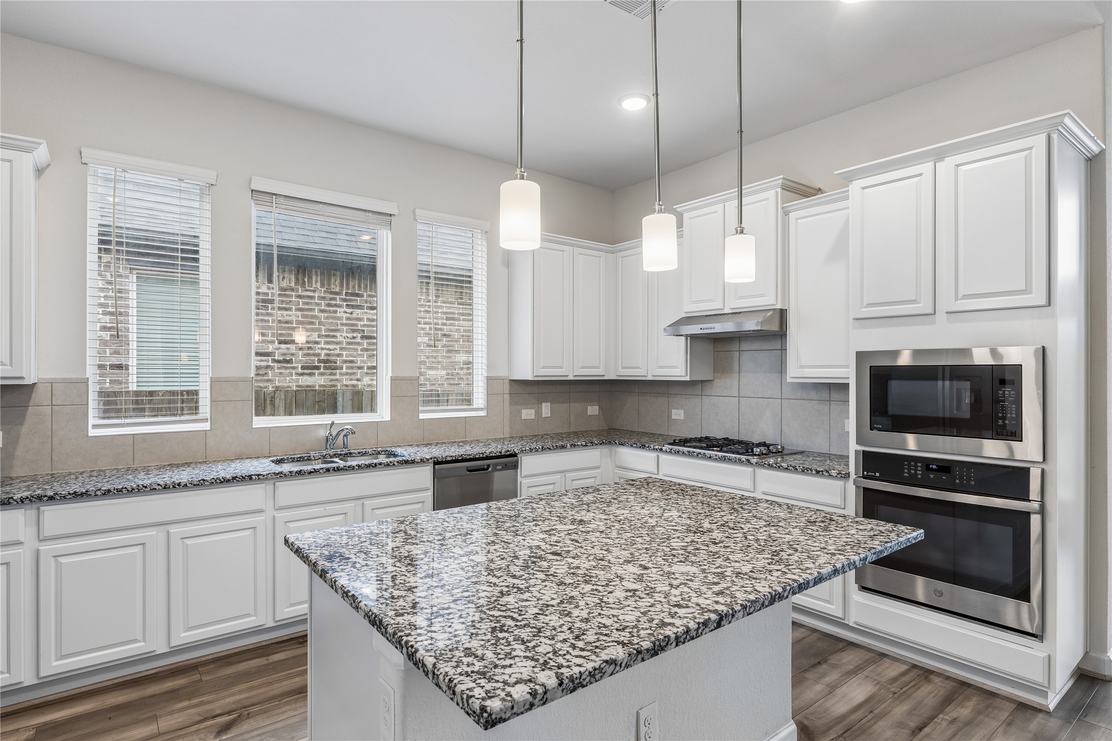 298 Wild Pecan Loop Buda, TX 78610 - Photo 13 of 40 a kitchen with stainless steel appliances granite countertop a sink stove and oven