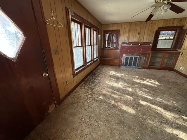 a view of an empty room with a fireplace and a window