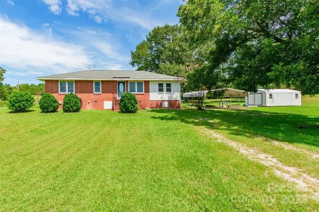 a front view of a house with a garden and trees