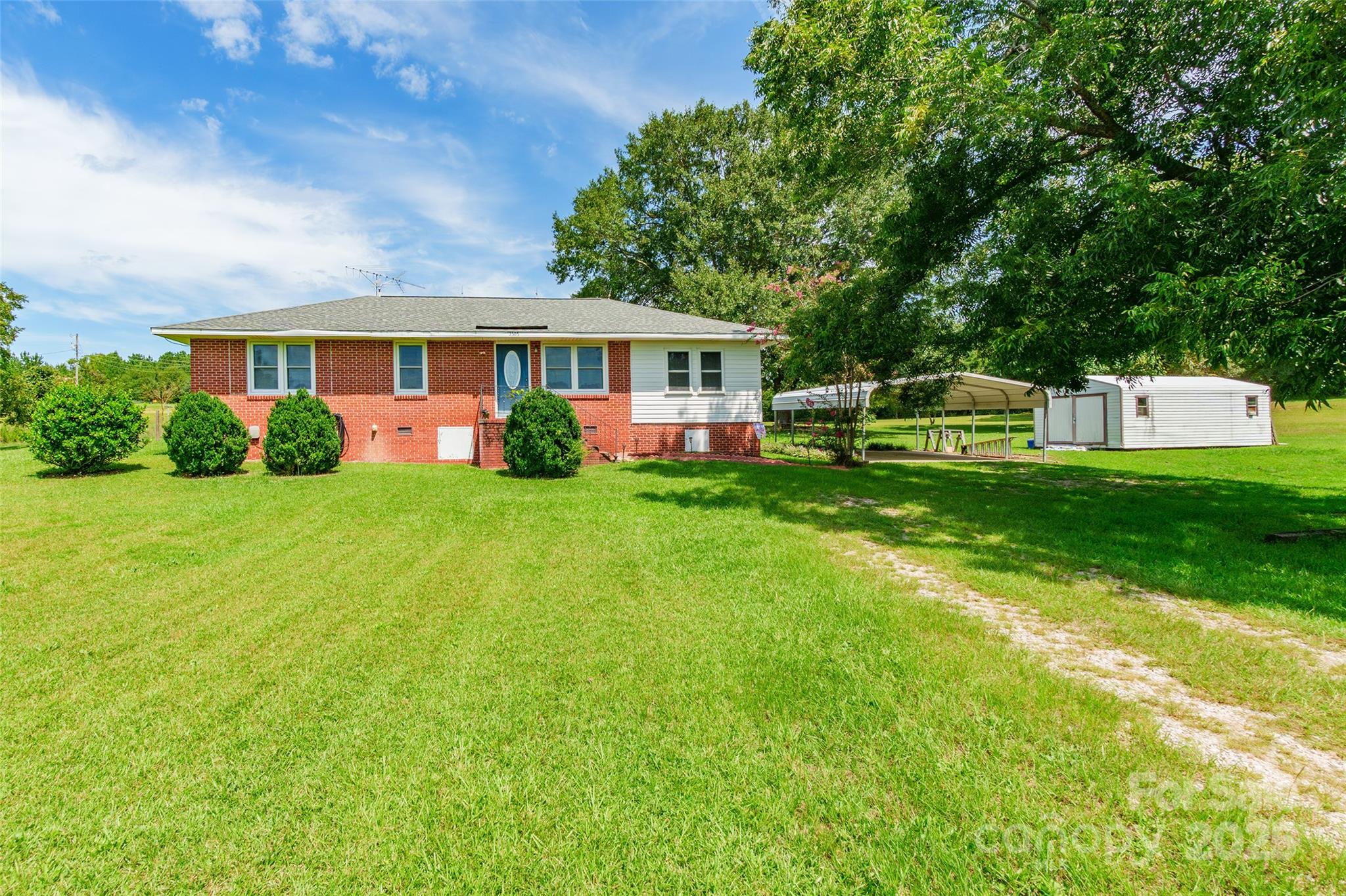 a front view of a house with a garden and trees