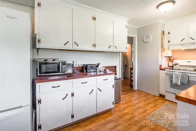 a kitchen with granite countertop white cabinets and stainless steel appliances