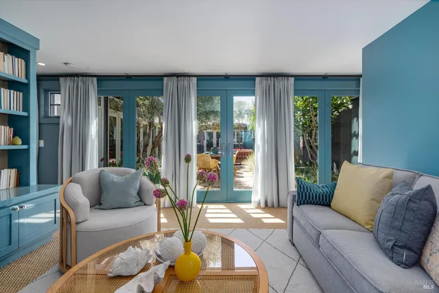a living room with furniture a flat screen tv and a floor to ceiling window