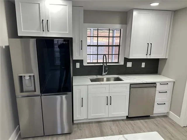 a kitchen with a refrigerator sink and cabinets