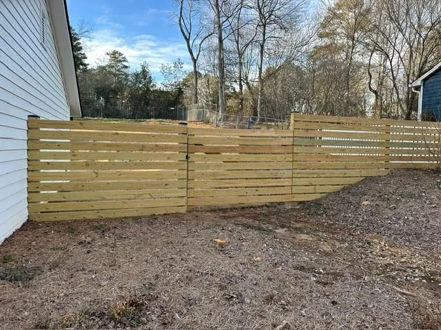 a view of a yard with wooden fence